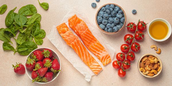 Aliments anti-inflammatoires pour la ménopause : saumon, épinards, fruits rouges, noix et huile d’olive, essentiels pour renforcer le système immunitaire et réduire l’inflammation naturellement.