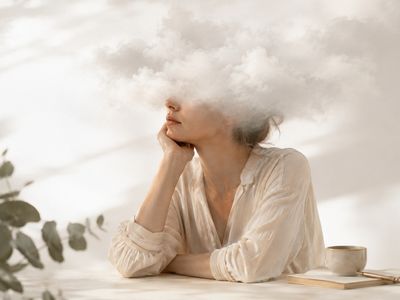 Femme assise de profil avec un nuage de brouillard à la place de la tête, illustrant le brouillard mental, les difficultés de concentration et les troubles cognitifs souvent ressentis en préménopause et en ménopause.
